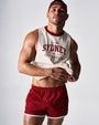 Man wearing a 'Sydney Social Club' tank top and red shorts on a plain background