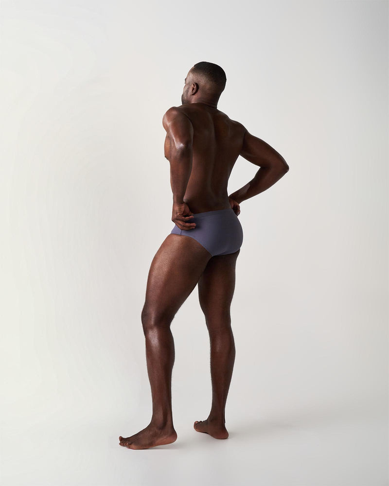 Man wearing a gray swim briefon a white background